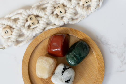 Dörtes Innerjourney Heilstein-Set auf Holzteller mit Makramee als Deko.